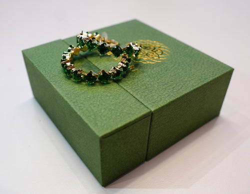 Golden earrings with green crystals