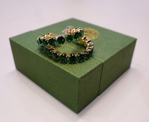 Golden earrings with green diamonds