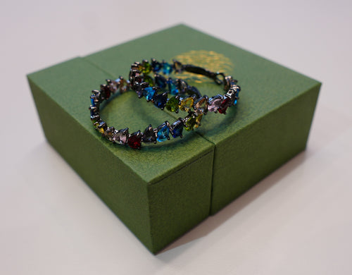 Round black earrings with pink, blue, yellow and green diamonds