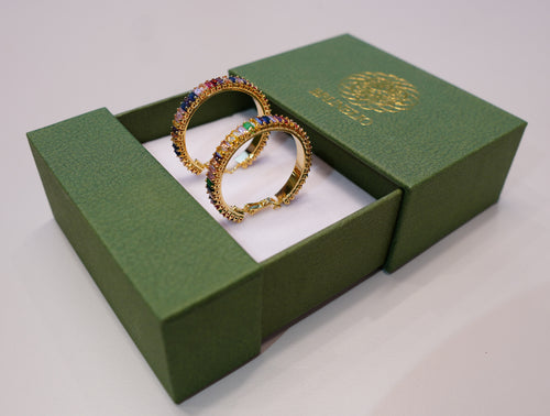 Round, gold earrings with green, blue, purple, yellow, pink, and other colored diamonds.