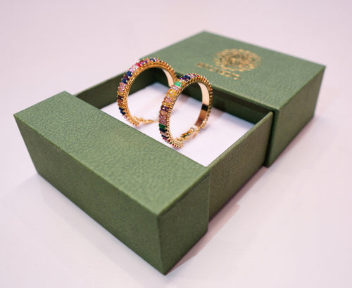 Round, gold earrings with green, blue, purple, yellow, pink, and other colored diamonds.